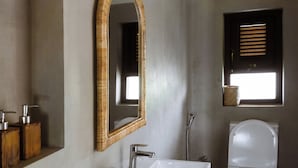 A bathroom with a white sink, a mirror, a toilet, and a window with blinds. - Samba Ahangama (Ahangama)
