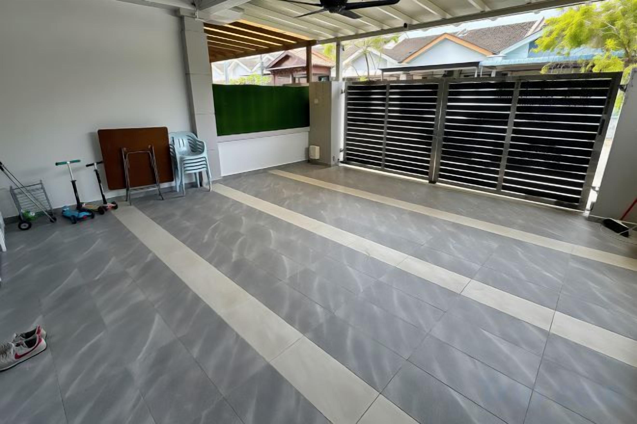 A spacious indoor area with a tiled floor, a green wall, and a large metal gate.