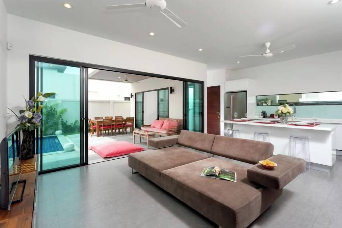 Una sala de estar moderna con un sofá, un comedor y una cocina.