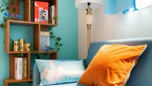 A room with a blue sofa, a wooden bookshelf, and a floor lamp. - Senju gawaracho 2･3F (Tokyo)