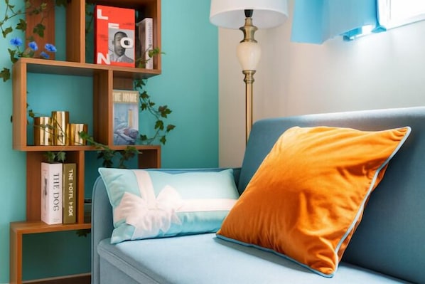 A room with a blue sofa, a wooden bookshelf, and a floor lamp. - Senju gawaracho 2･3F (Tokyo)