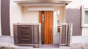 A modern entrance with a wooden door and metal gates. - Tokyo　Ikebukuro　villa (Tokyo)