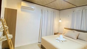 A hotel room with a bed, a nightstand, an air conditioning unit, and a wooden ladder. - Time To Sleep — Casa Ala Una (Butuan)