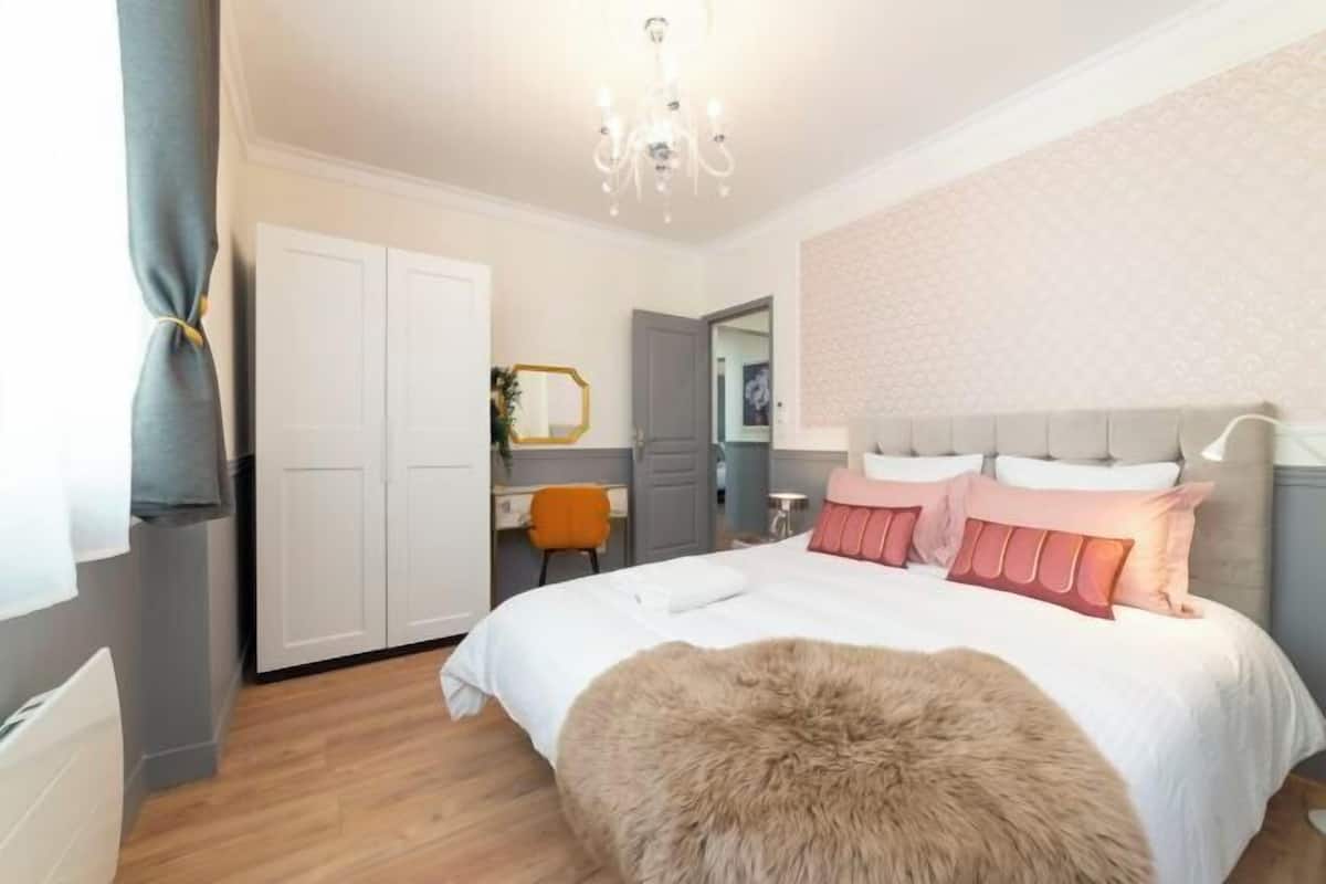 Une chambre à coucher avec un lit, un tapis moelleux, une commode, un miroir et une chaise.