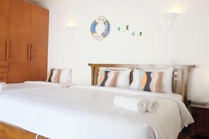 Een hotelkamer met een groot bed, een houten garderobe en wandlampen.
