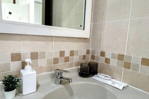 Ein Badezimmer mit Waschbecken, Spiegel und Pflegeprodukten.
