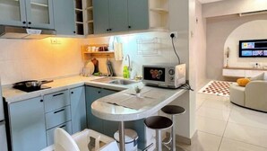 Een moderne keuken met een centraal eiland, barstoelen en een ingebouwde magnetron.