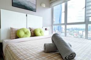 Une chambre d’hôtel avec un grand lit, une vue sur la ville et un design moderne.