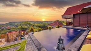 A pool with a sunset view, a wooden building, and a statue. - Sebuluh Sunset Hill (Bali)