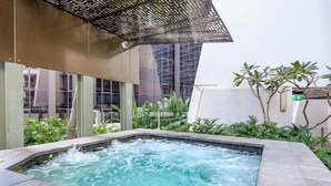 A hot tub area with a view of a building and greenery. - Arcade in the Sky - Views, Games & Vibes (Brisbane)