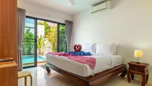 Une chambre avec un grand lit, une petite table de chevet, une chaise et une vue sur une piscine.