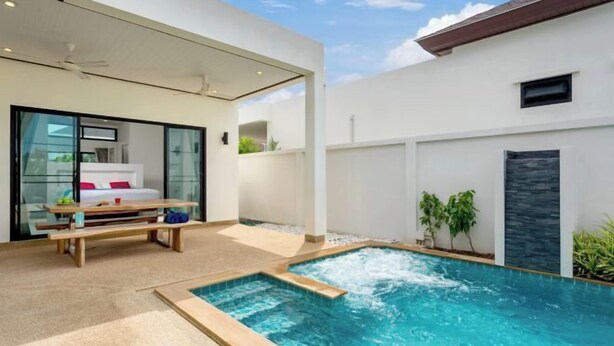 Un espace piscine extérieur moderne, doté d’une terrasse en bois et d’un bain à remous.