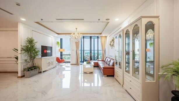 Un salon spacieux au design moderne, comprenant un grand canapé, un téléviseur et un meuble décoratif.
