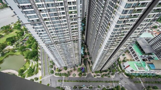 A high-rise residential building with multiple floors, a central courtyard, and surrounding greenery.