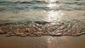 Ein Strand mit sanft anschwellenden Wellen.