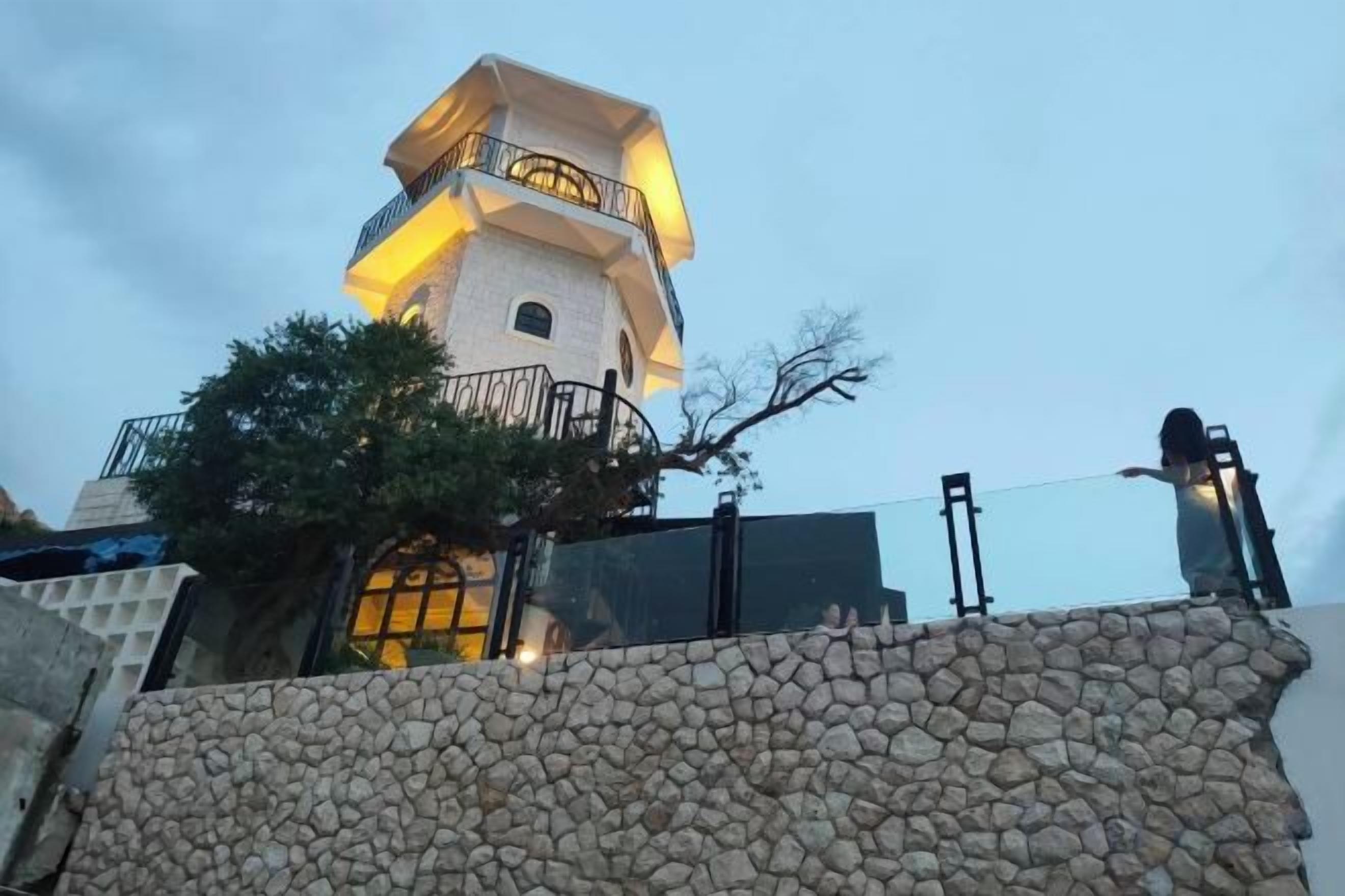 A stone wall with a building in the background.