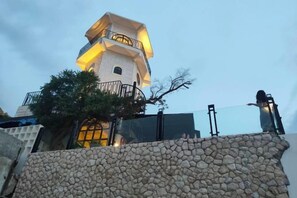 A stone wall with a building in the background. - Baan Chid Haad (Chon Buri)