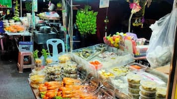A food stall with various seafood and prepared dishes displayed in containers.