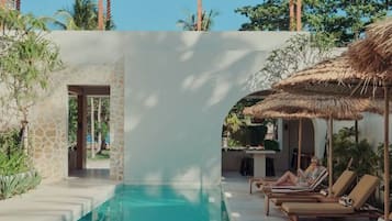 A pool area with lounge chairs and a pergola.