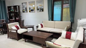 A living room with a sofa, chairs, a coffee table, and a bookshelf. - Sweet home (Concord West)