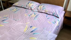 A bed with a floral patterned bedspread and matching pillows. - Sweet home (Concord West)