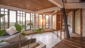 A spacious room with large windows, a wooden ceiling, and a dining area. - BAz Penthouse (Bali)