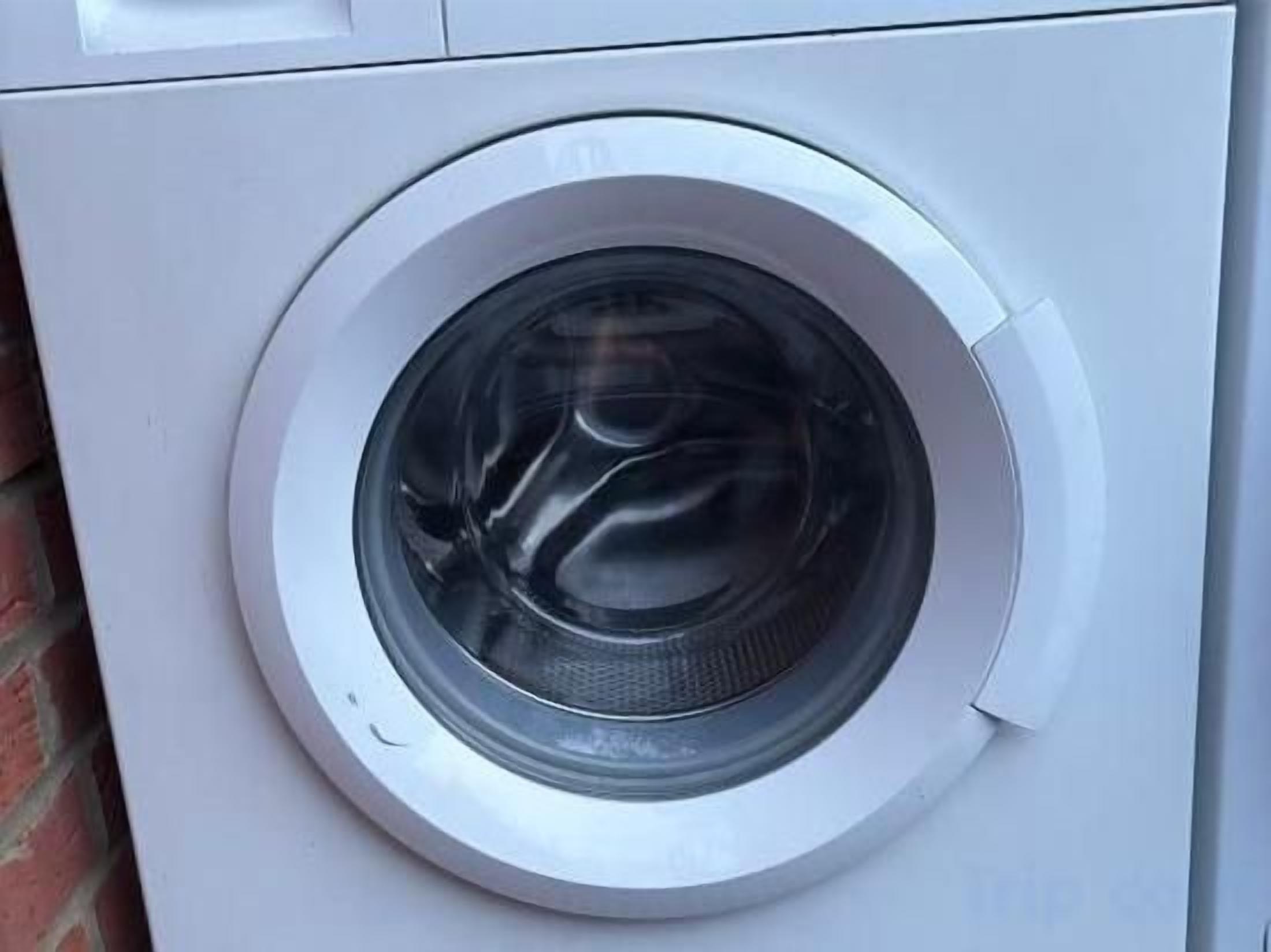 Et hvidt vaskemaskine set fra forsiden.