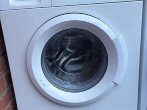 A front view of a white washing machine. - Min Su Rooms (Stanwell)
