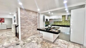 A modern kitchen with a marble floor, white cabinetry, and a stone backsplash. - Casa jomtien village Pattaya Sea Sky Pool Villa (Pattaya)