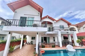 A two-story house with a balcony, a swimming pool, and a red-tiled roof. - Casa jomtien village Pattaya Sea Sky Pool Villa (Pattaya)