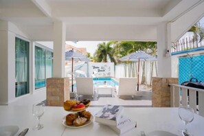 A dining area with a table set for two, a plate of pastries, and a menu. - Baba beach (Pattaya)