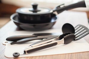 A kitchen counter with a pot, a spatula, and a pair of tongs. - Shiinamachi house (Tokyo)
