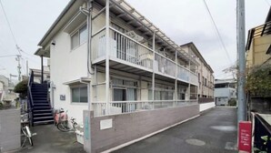 A multi-story building with a balcony on the second floor, a staircase leading to the entrance, and a bicycle parked outside. - Shiinamachi house (Tokyo)