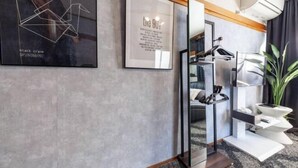 A modern hotel room with a large mirror, a framed abstract artwork, and a small plant. - Shiinamachi house (Tokyo)