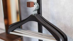 A black hanger with a wooden knob, attached to a metal rod. - Shiinamachi house (Tokyo)