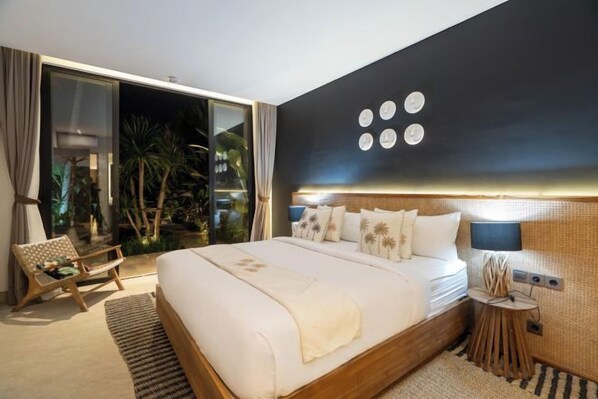 A modern hotel room with a large bed, a side table, a chair, and a view of the outdoors. - Villa Kyson Art Ubud by BaliSuperHost (Bali)