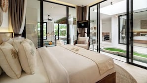 A modern bedroom with a large bed, a TV, and a view of a pool and outdoor area.