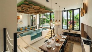A modern dining area with a pool view, a ceiling fan, and a dining table set for four.