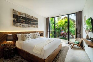 A modern bedroom with a large bed, a flat-screen TV, and a sliding glass door leading to a garden. - Villa Kyson Art Ubud by BaliSuperHost (Bali)