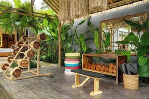 A wooden deck with a weightlifting station, a bench, and a shelf with logs. - Villa Kyson Art Ubud by BaliSuperHost (Bali)