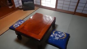 A traditional Japanese tatami mat room with a wooden table and two cushions. - Private Villa Gifu Takayama (Takayama)