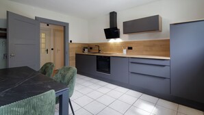 A modern kitchen with grey cabinets, a black countertop, and a built-in oven. - Stylish vacation apartment in Germany's highest train station (Feldberg (Schwarzwald))