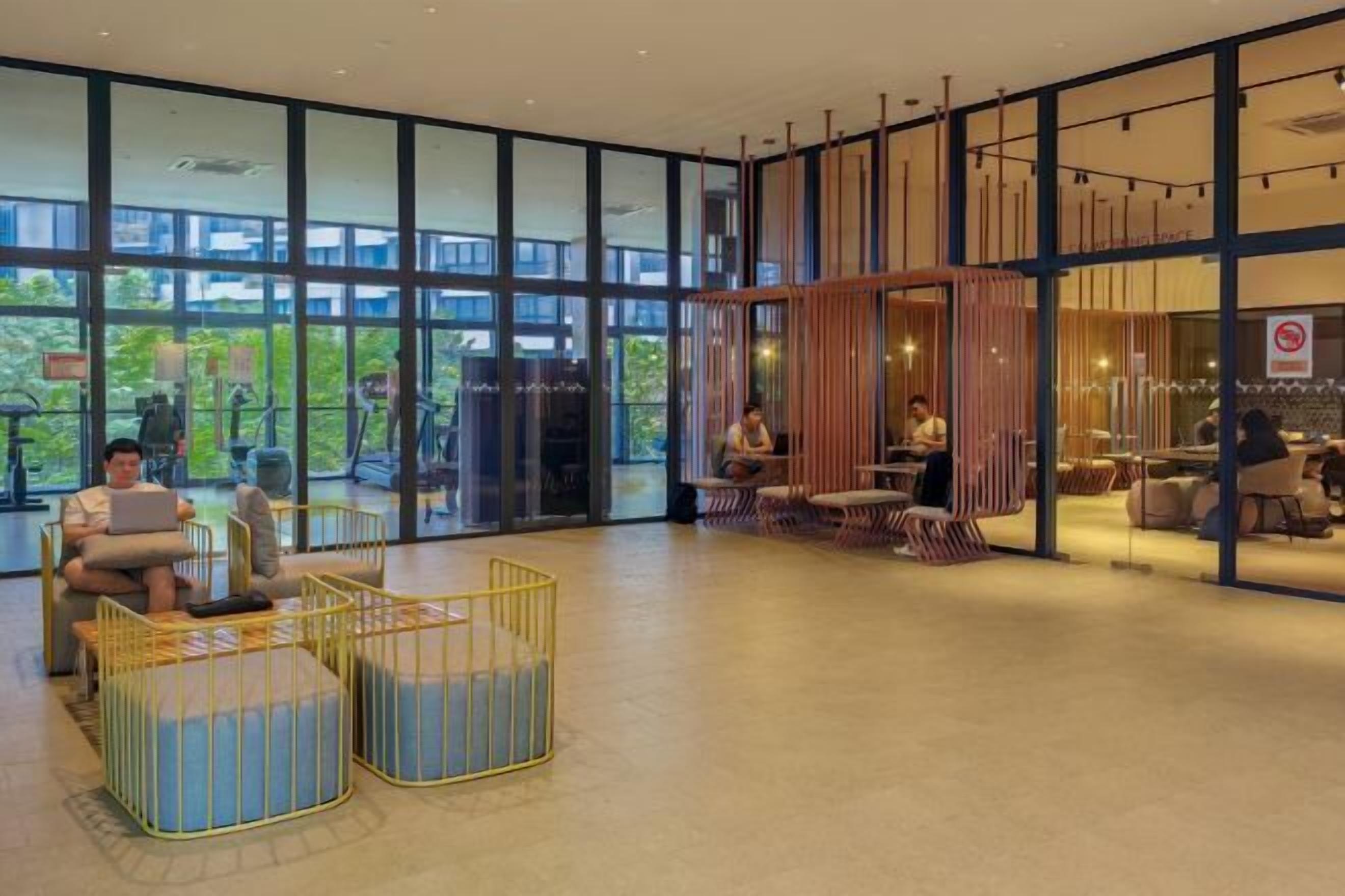 A spacious lobby with large windows, seating areas, and a visible restaurant section.