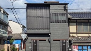 A modern building with a flat roof, two dark-colored doors, and a vertical panel design. - Moonlight Inn Kujo (Kyoto)
