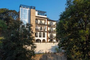 Un immeuble à plusieurs étages, doté d’une structure moderne en verre sur les niveaux supérieurs et d’une architecture plus traditionnelle en dessous.