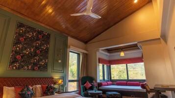 A room with a bed, a seating area, and a table.