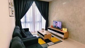 Un salon moderne avec un canapé, un téléviseur et une petite table.