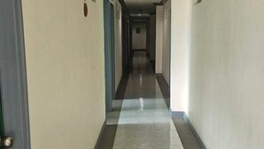 A long, narrow hallway with a tiled floor and doors on both sides. - Green Mellow Court Capitol Avenue (Dipolog)