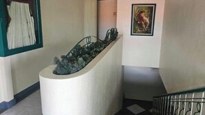 A staircase with a planter on the left and a framed painting on the right. - Green Mellow Court Capitol Avenue (Dipolog)