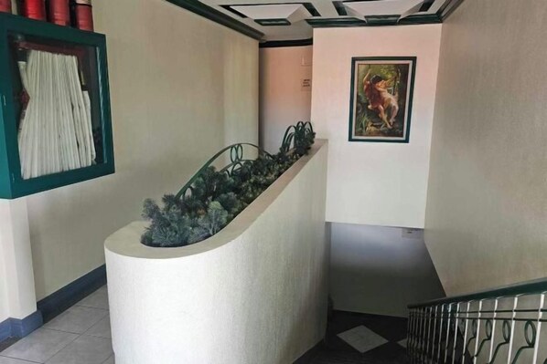 Eine Treppe mit einem Blumentopf auf der linken Seite und einem gerahmten Gemälde auf der rechten Seite.